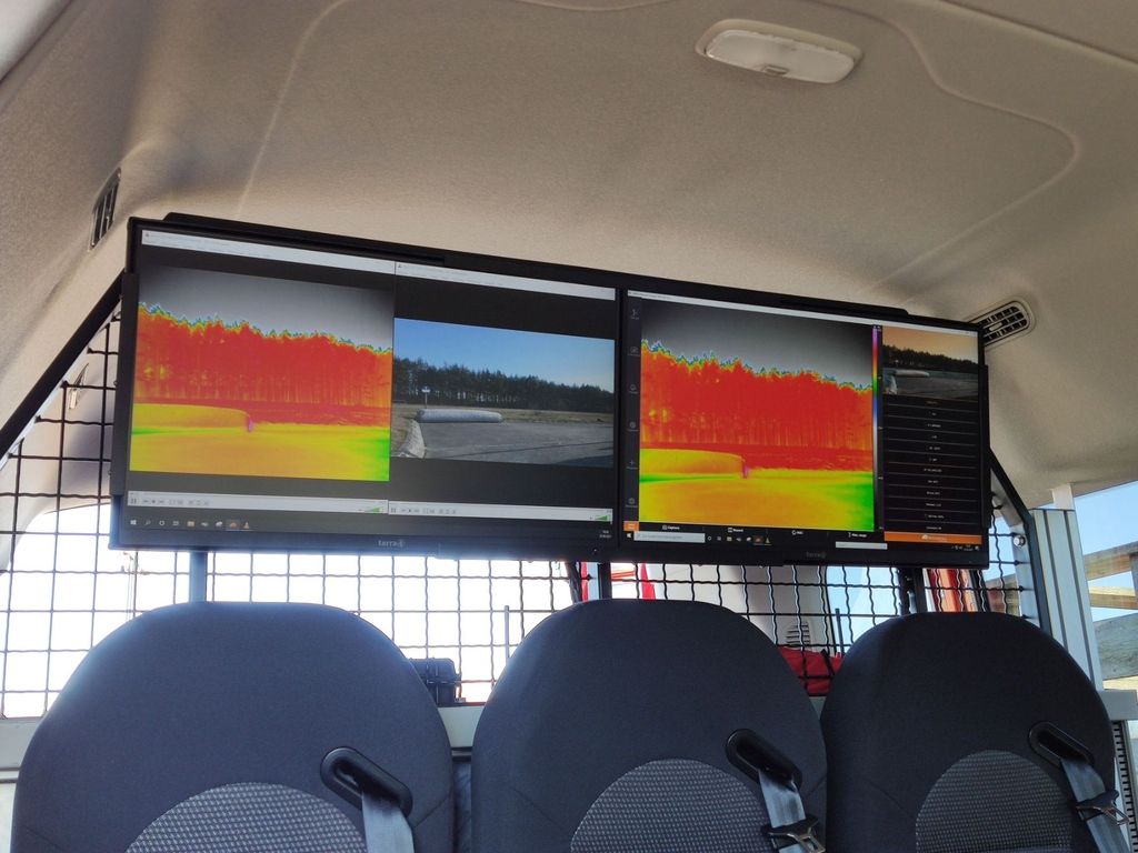 Zwei Monitore im Einsatzfahrzeug zeigen Drohnen-Livebilder und Thermografieaufnahmen.